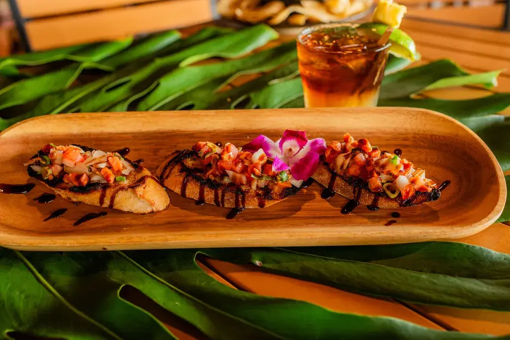 Salmon Bruschetta at Voyagers: salted salmon, tomato and green onion on crostini with a balsamic drizzle and an orchid