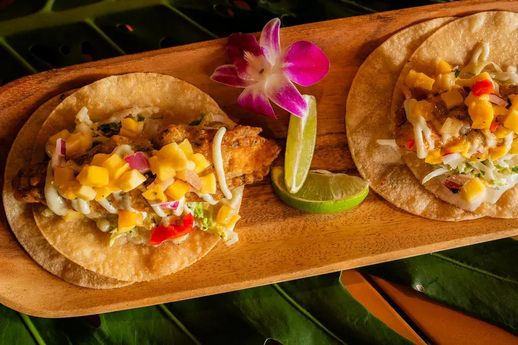 Fresh Catch Fish Tacos at Voyagers: furikake beer-battered fish with Asian slaw and mango salsa on corn tortillas, with lime