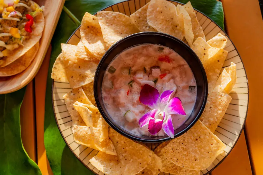 Tahitian-style ceviche at Voyagers in Kailua-Kona: fresh catch in coconut milk with lime and cilantro, an orchid on top, ringed with corn chips