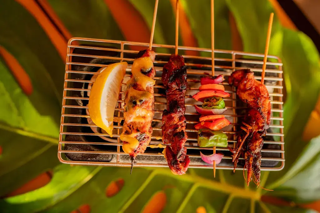 Yakitori Skewers at Voyagers on a tabletop grill: miso-glazed chicken, shiso meatball, garden vegetables, garlic shrimp and teriyaki beef